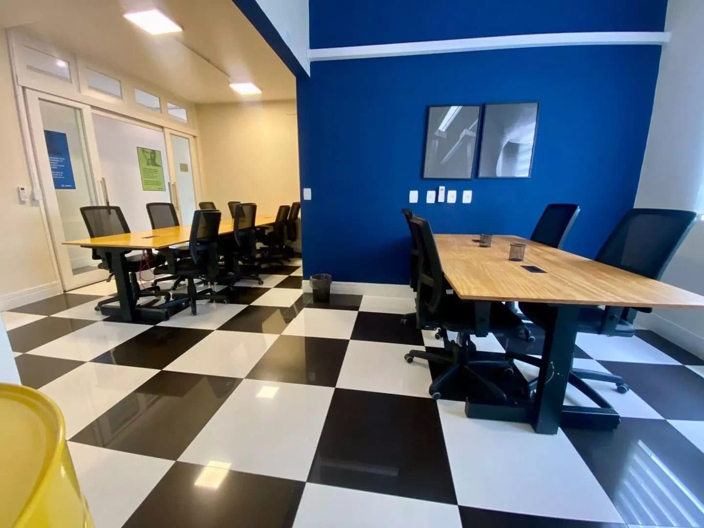 Sala privativa do Brains Batel com piso xadrez e parede azul, em Curitiba