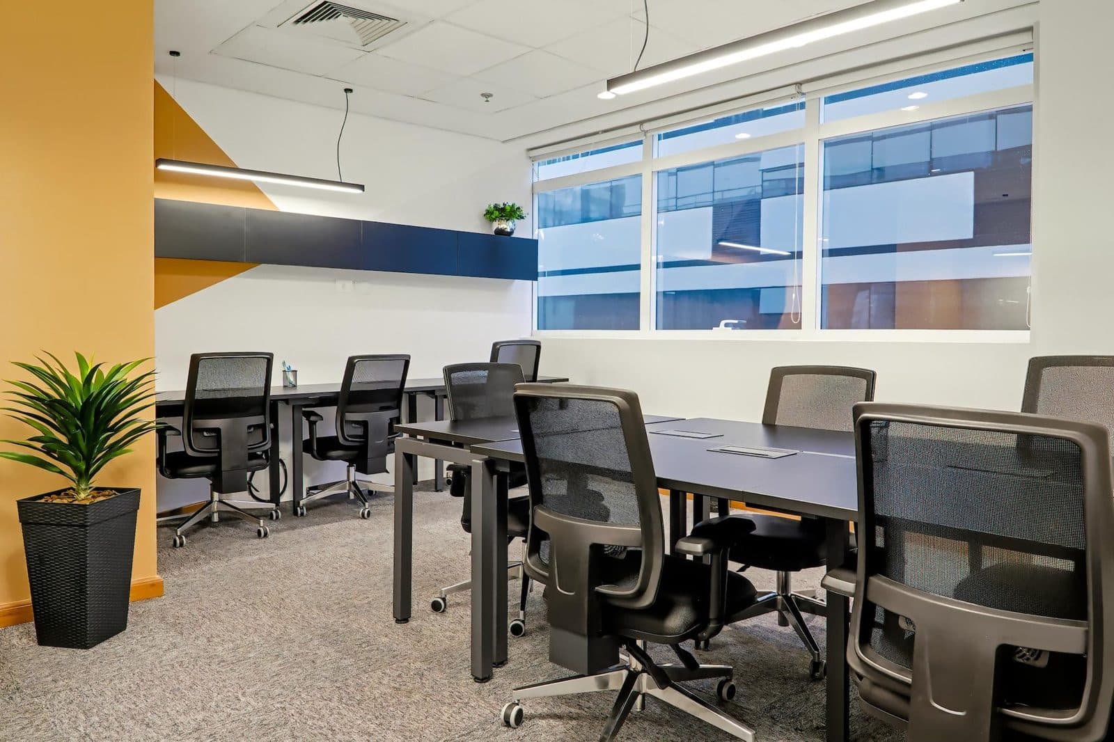 Interior de sala privativa da Brains Coworking configurada para equipe, com estações de trabalho, em Curitiba